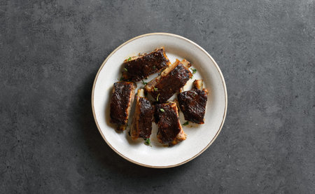 Pork ribs on plate over dark stone background with copy space. top view, flat lay