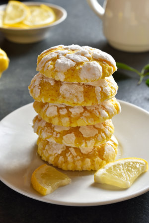 Stack of lemon crinkle cookies on plate over dark stone background. close up viewの写真素材
