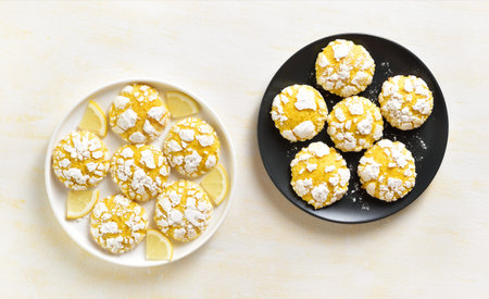 Homemade lemon crinkle cookies on plate over light background. Top view, flat lay