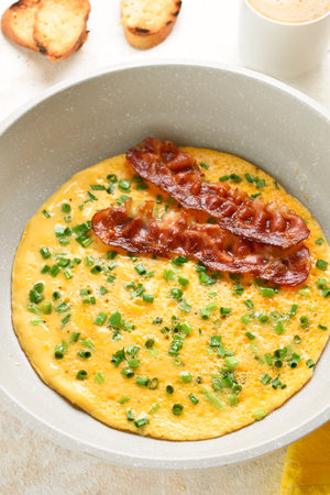 Omelette with cheese and green onion in pan on light background. Tasty healthy dish for breakfast. Close up viewの写真素材
