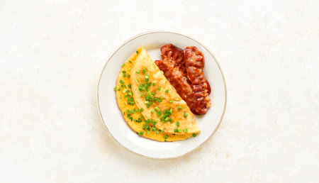Omelette with cheese and green onion on plate over light background with free space. Tasty healthy dish for breakfast. Top view, flat lay.の写真素材