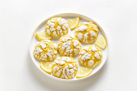 Lemon crinkle cookie on plate over white stone background. Close up view