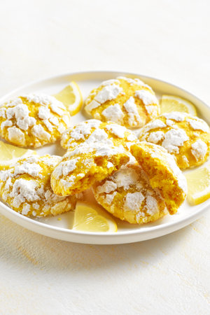 Homemade lemon crinkle cookies on white plate over light background. Close up viewの写真素材