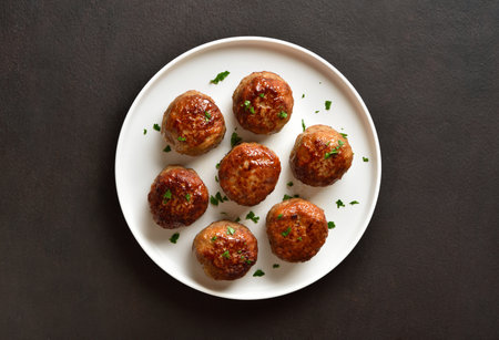 Homemade cutlets from minced meat on plate over dark background. Top view, flat layの写真素材