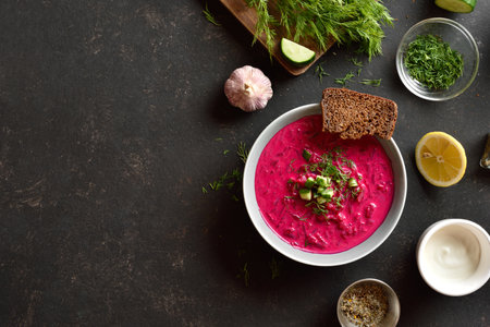 Beet cream soup with yogurt, cucumbers and dill in bowl on black background with free space. Cold summer soup. Top view, flat layの写真素材