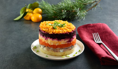 Shuba salad. Dressed herring, herring under fur coat. Christmas layered vegetable salad with herring and boiled vegetables. Dark background, close up viewの写真素材