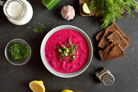 Beet cream soup with yogurt, cucumbers and dill in bowl on dark background. Cold summer soup. Top view, flat layの写真素材