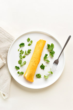 French omelette with cheese garnished with cilantro. Healthy diet food concept. Light background, top view, flat layの写真素材