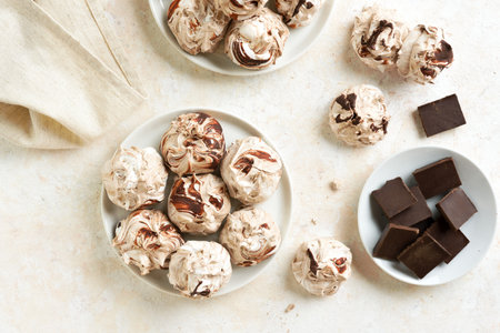 Chocolate meringue cookies on light background. Top view, flat layの写真素材