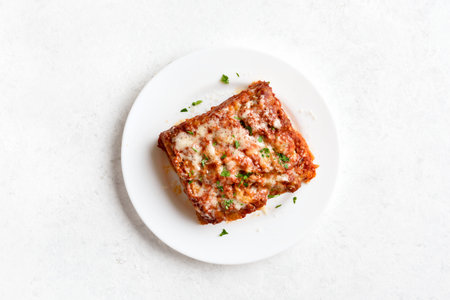 Homemade lasagna with bolognese sauce and ricotta cheese on white background. Top view, flat layの写真素材