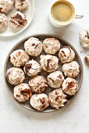 Delicious chocolate meringue cookies and cup of coffee on light background. Top view, flat layの写真素材
