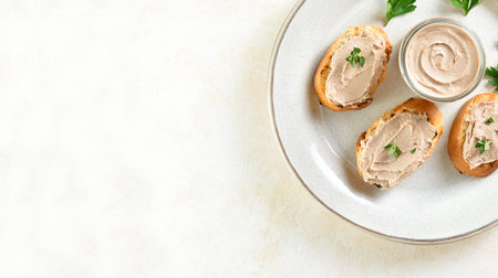 Close up view of chicken liver pate on toasted bread on plate over light background with copy space....