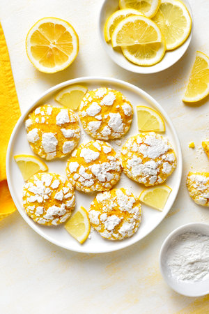 Homemade lemon crinkle cookies on white plate over light background. Top view, flat layの写真素材