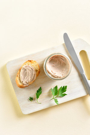 Chicken liver pate on wooden cutting board on light background with free space. Top view, flat layの写真素材