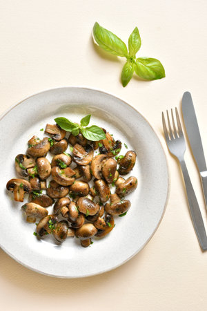 Cooked mushroom with greens on plate on light stone background. Vegetarian vegan or heatlhy diet food concept. Top view, flat layの写真素材