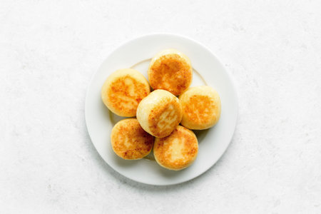Cottage cheese pancakes (syrniki or curd fritters) on white background. Top view, flat layの写真素材