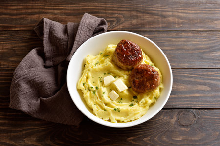 Mashed potatoes with minced meat cutlets in bowl on wooden background. Healthy comfort food. Close up viewの写真素材