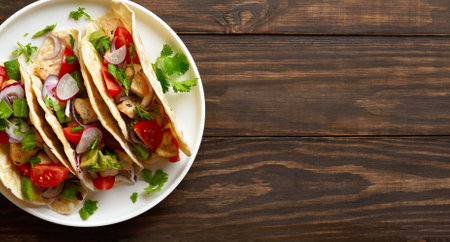 Tacos with vegetables and meat on white plate on brown wooden background with free space. Top view, flat layの写真素材