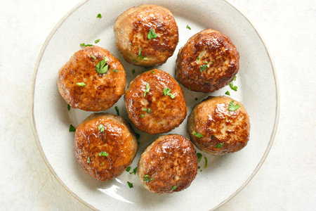 Close up view of minced pork and beef cutlets on plate over light background. Top view, flat lay