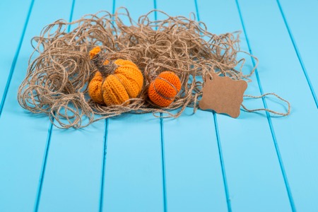 Homemade Halloween pumpkins, twine and card on the blue wooden background.の写真素材