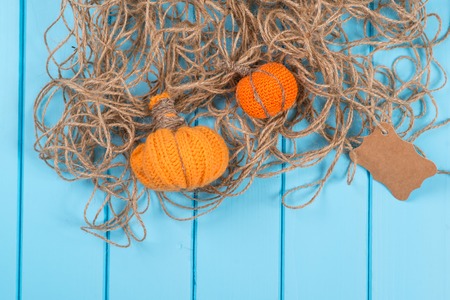 Homemade Halloween pumpkins, twine and card on the blue wooden background.の写真素材
