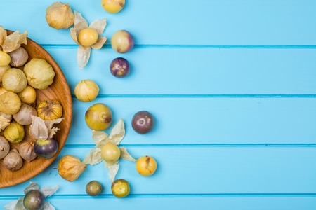Ripe physalis in the blue wooden bowl.の写真素材