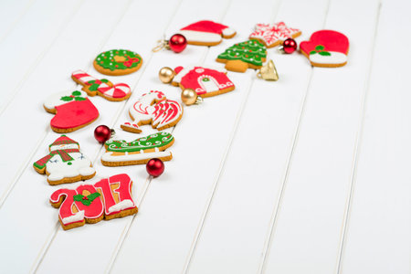 Christmas colorful gingerbread cookies on the white wooden background. Winter holidays concept....