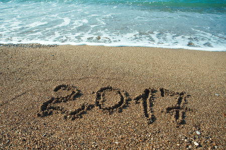 The Numbers 2017 on beach. New year holiday concept .