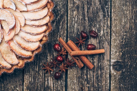 Apple pie tart on the rustic wooden background. Ingredients - apples and cinnamon .Top view.の写真素材