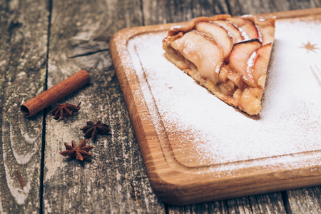 A piece of sliced apple pie with cinnamon on the vintage wooden background texture.の写真素材