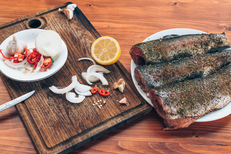 Fresh trout with spices and seasoning on the cutting board.の写真素材