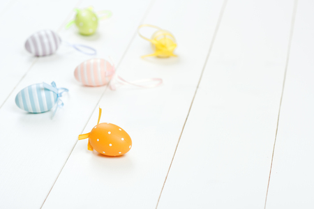 Easter card. Scattered pastel Easter eggs on the wooden background. Selective focus.の写真素材