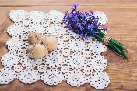 Three wooden easter eggs and spring flowers. Selective focus.