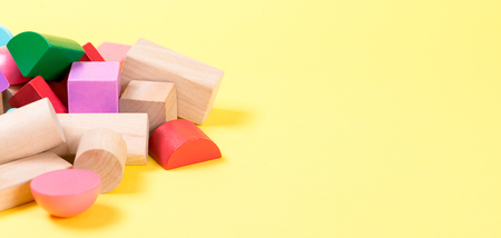 Colorful wooden building blocks on the yellow background.の写真素材