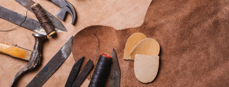 Cobbler tools in workshop on wooden table . Top view.
