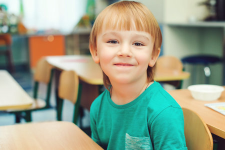 portrait of cute little boy in the classroom, indoors