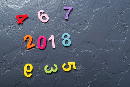New year concept 2018. Colored numbers scattered on the black background.