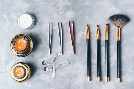 A set of tools, accessories and cosmetic for the care of the eyebrows on grey background. Brushes, combs, brow gel, brow scrub, tweezers.の写真素材
