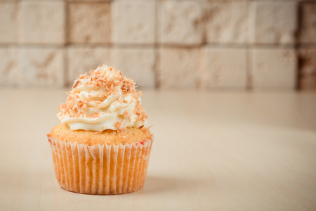 Colorful cupcake on table on brick wall background.の写真素材