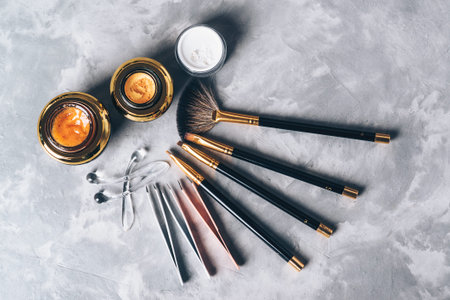 A set of tools, accessories and cosmetic for the care of the eyebrows on grey background. Brushes,...