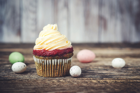 Tasty Easter cupcake and easter eggs around on the wooden bakground.の写真素材