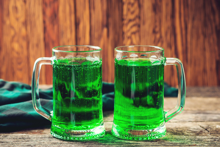 Two mug of green beer on the rustic wooden background.の写真素材