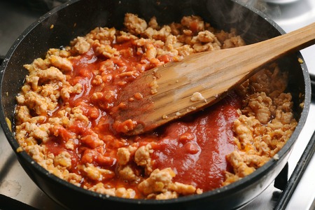 Fried chicken forcemeat with tomato sauce in pan.の写真素材