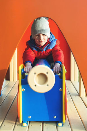 Cute little boy playing on playground in a city park.の写真素材