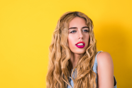 Sexy girl with bright makeup on yellow background. Sale and shopping concept.の写真素材