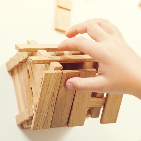 Small wooden house model. Construction wooden house. My house concept. Kid builds small house, close up. Top view.の写真素材