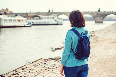 Woman tourist enjoying Prague view. Follow me to Prague. Back view of woman standing at Vltava riverbank.の写真素材