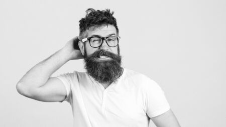 Confused bearded young man in glasses. Hipster trying to solve difficult problem. Bearded guy tries to gather with thoughts. Brutal man thinks about something on white backgroundの写真素材