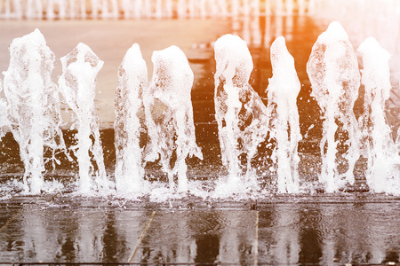 Water fountain in the city plaza, close up. Gush of water of a fountain. Jet of water in city fountainの写真素材