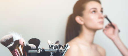 Professional makeup brushes and tools. Mockup of makeup woman. Fashion makeup, beauty, and cosmetics. Set of brushes on blurred background, with copy spaceの写真素材